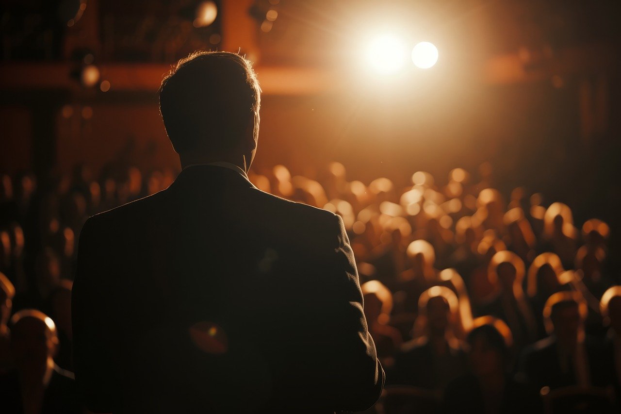 A speaker in the spotlight before his audience.